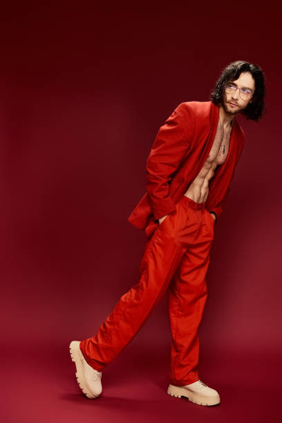 istock A young man in a striking red outfit showcases confidence against a deep red background 2184348565