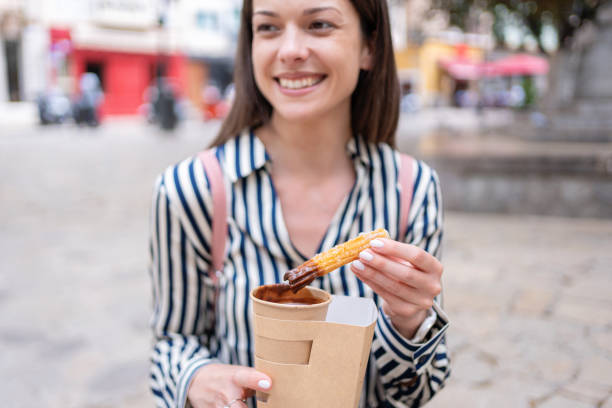 istock A young woman relaxes on a bench with churros while taking a break from sightseeing in Palma de Mallorca, Spain 2184354415