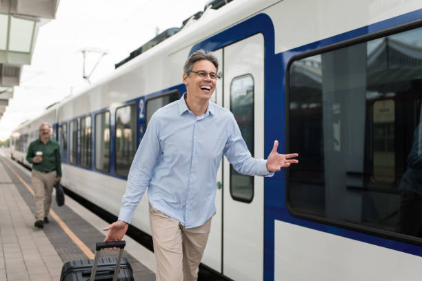 istock Ecstatic man running to board on train on railway station 2184355421