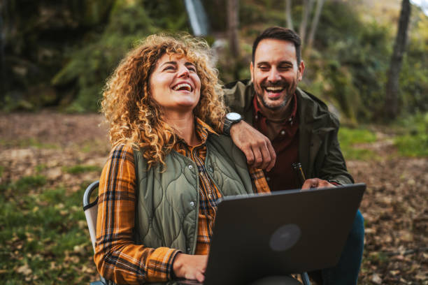 istock wife hiker work remote on laptop in front waterfall with husband nearby 2184359766