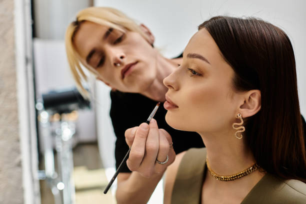 istock A passionate queer makeup artist enhances a young womans beauty in a modern studio 2184363512