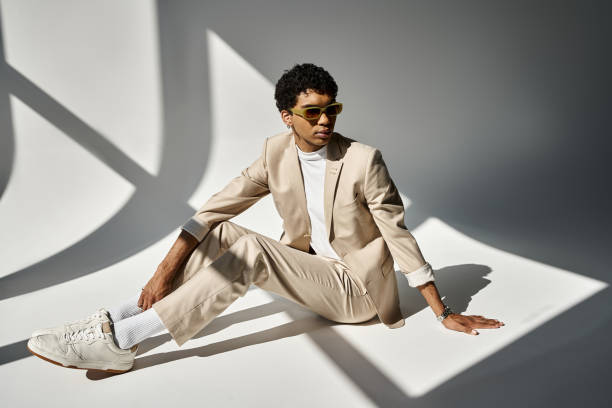 istock Stylish man poses in a modern outfit against a backdrop of soft shadows in an artistic setting 2184365564