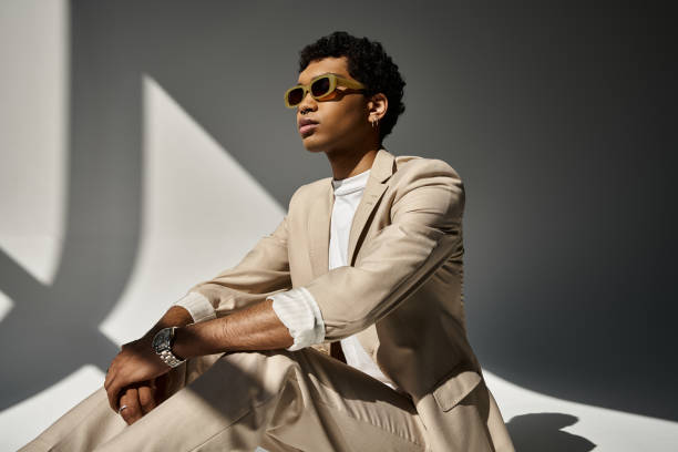 istock Stylish man relaxing in a modern setting with unique shadows, exuding confidence and elegance 2184365570