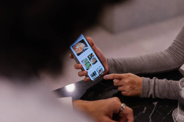 istock Couple At A Cafe Looking At Digital Menu 2184366060