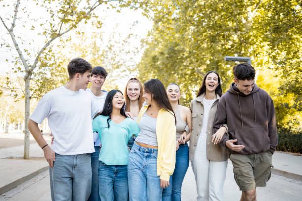 istock A group of 8 young people between 18 and 25 years old of different ethnicities walk through a park in the afternoon.Concept of millennial youth groups. 2184366122