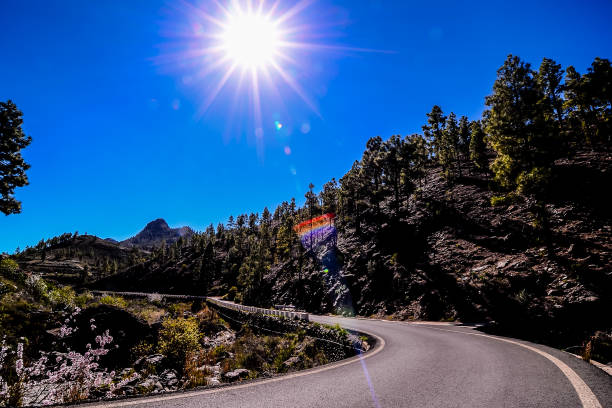 istock A road with a mountain in the background and a bright sun shining on it 2184366244