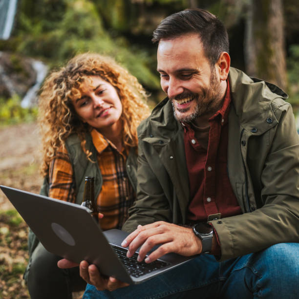 istock man hiker work remote on laptop in front waterfall with wife nearby 2184366273