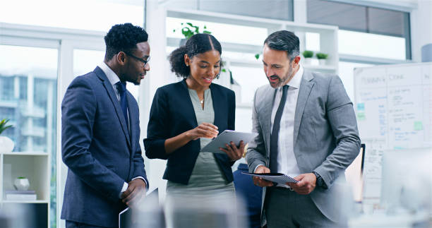 istock Business people, tablet and discussion with group in office, results or feedback with application at company. Woman, men and digital touchscreen with review, scrum and documents at insurance agency 2184371265