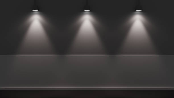 istock Three spotlights illuminating a dark wall and floor in a minimalist studio 2184373299