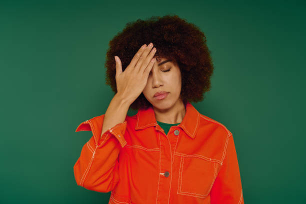 istock A young Black woman in a bright orange outfit shows emotion in a studio 2184373742