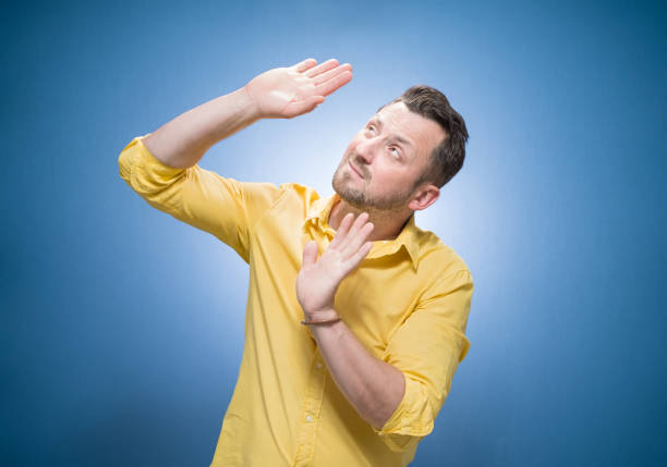 istock Discrimination. Young man looking up to boss and defending herself over blue background, dresses in yellow shirt. Victim concept 2184374590