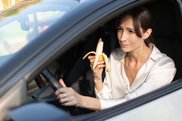 istock Woman eating banana while driving 2184375955