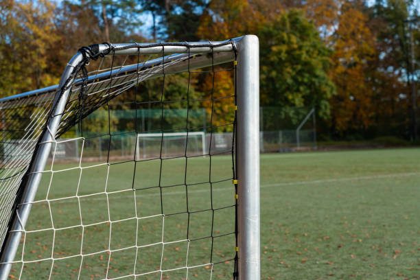 istock Empty soccer field with goalpost under autumn trees in daylight 2184379759