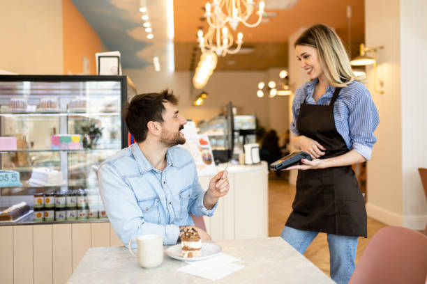 istock Man making a contactless payment with his credit card at a restaurant 2184383460