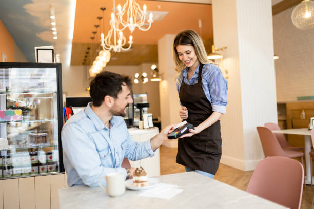 istock Man making a contactless payment with his credit card at a restaurant 2184383777