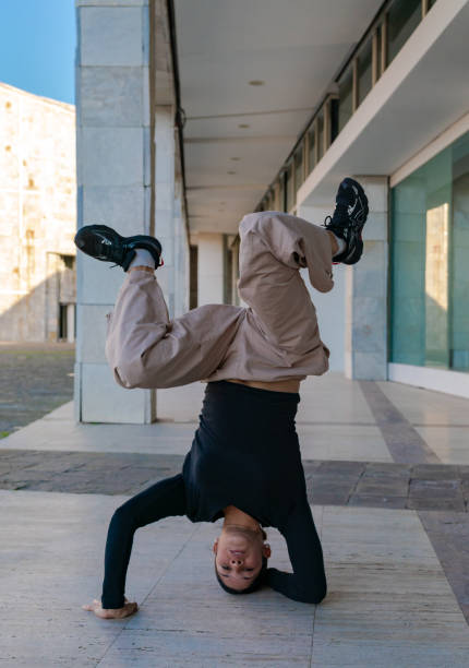 istock A young woman does a face down pose on a sidewalk breakdancing. Space to write 2184383870