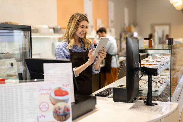istock Smiling young baker at the checkout counter. 2184384863
