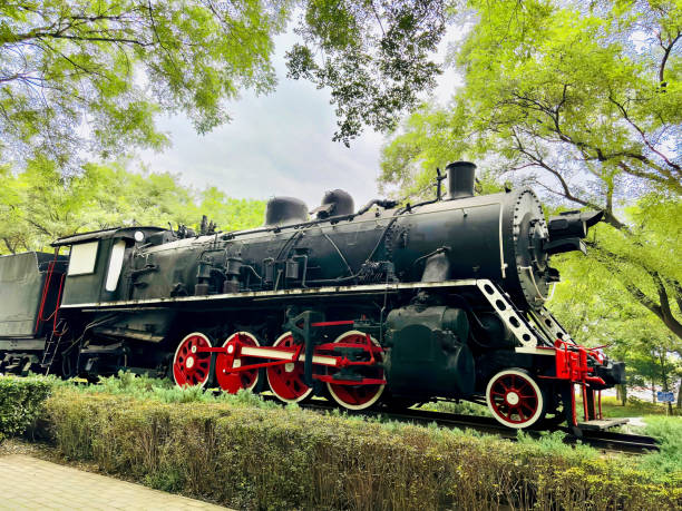 old train station-historic steam train passes through the fields.Frontal view of old train engine in china