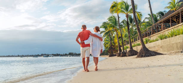 istock Couple in love hugging while walking on a sandy exotic beach. They have an evening walk by Trou-aux-Biches seashore on Mauritius island. People relationship and tropic honeymoon vacations concept 2184387738