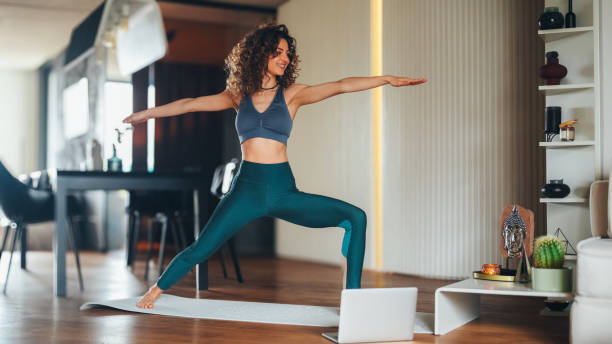 istock Female exercising yoga at home with online video class 2184389532