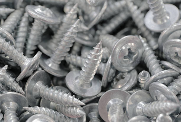 A lot of small galvanized screws, close up shot. Abstract background for DIY or construction industry.