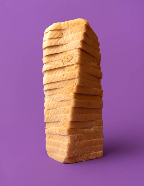 istock Soft toast bread, slices stacked on a purple table, low-angle view 2184389808