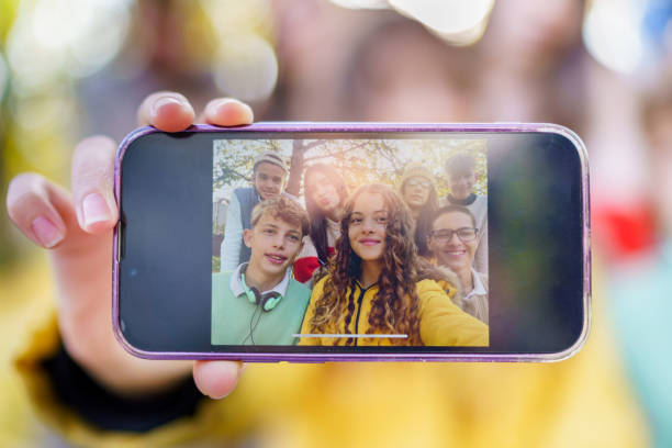 istock A group of teenagers are holding a mobile phone while taking a selfie 2184389917
