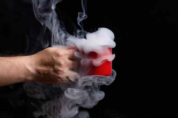 hand gracefully holds a red ceramic mug filled with swirling smoke, set against a dark background. This striking contrast evokes mystery and warmth, inviting contemplation and imagination
