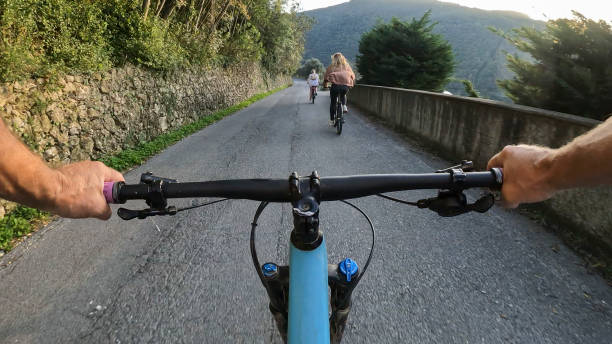 istock POV past bicycle handlebars to women riding rural road 2184390311