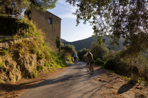 istock Mature couple ride bicycles on rural road 2184390460
