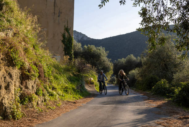 istock Mature couple ride bicycles on rural road 2184390677