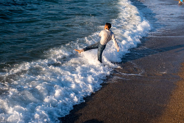 Young model having fun with waves by the sea