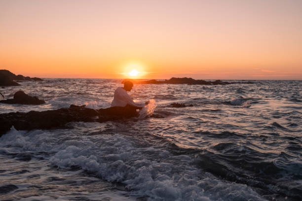 istock Young man having a vacation alone and having fun at the sea at sunset 2184392092