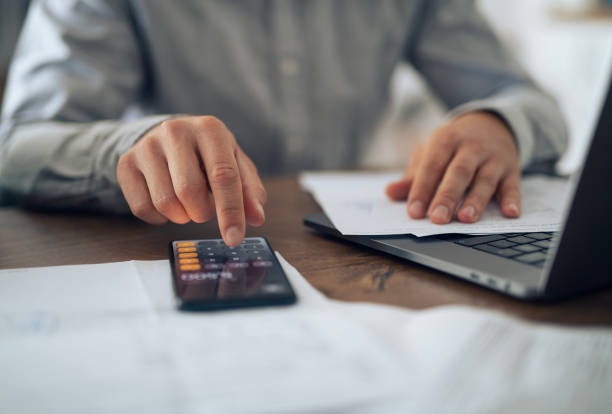 istock Close-up of a man calculating expenses and paying bills. 2184393826