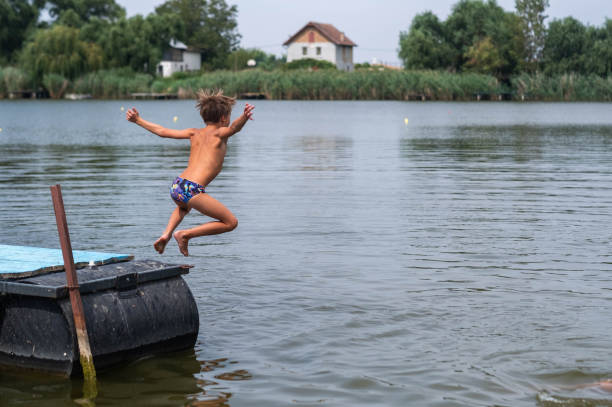 istock the boy jumps into the water 2184394280