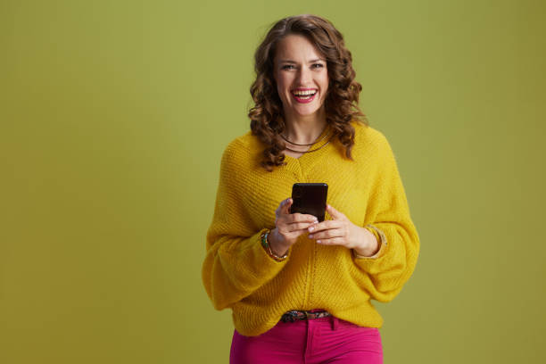 istock happy healthy woman in yellow sweater isolated on green 2184395607
