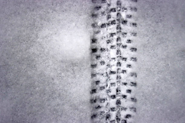 Detailed bicycle tire tread mark on fresh snow. Bike track pattern, texture left  in a winter environment. Monochrome tire print on snow, providing a contrast of black against white. Copy space
