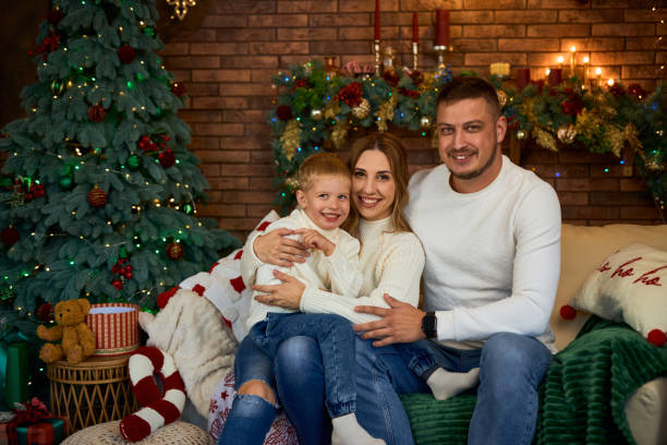 istock Happy family hugging warmly next to Christmas tree 2184396972
