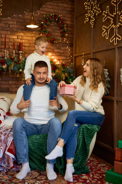 istock Happy family hugging warmly next to Christmas tree 2184397026