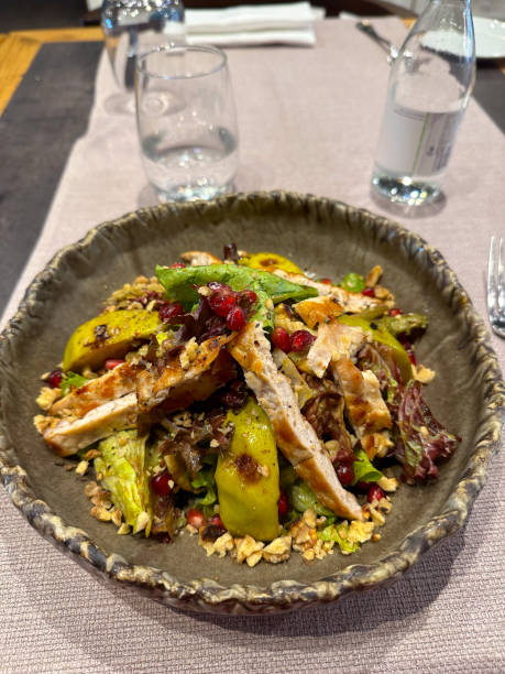 istock Vibrant salad is artfully presented in a rustic bowl, featuring grilled chicken, fresh greens, avocado slices, pomegranate seeds, and crunchy nuts. Appetizing dish highlights a colorful and healthy dining option perfect for any gourmet experience top view 2184411746