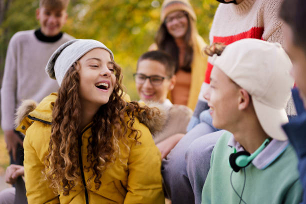 istock Teenagers are talking while sitting on a park bench 2184414478