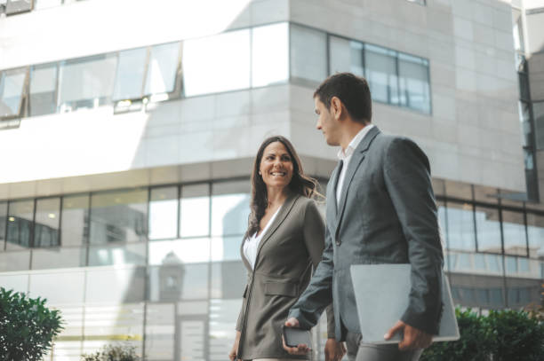 Professional Colleagues Walking Outside Corporate Building