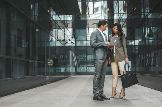 istock Business Professionals Discussing Outside Modern Office Building 2184417555