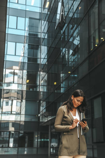 istock Professional Woman Using Smartphone Outside Office Building 2184417585
