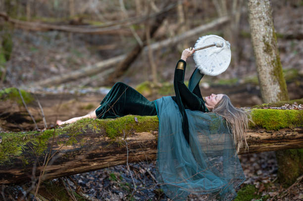 istock Woman playing a drum in a forest. Shallow depth of feld 2184417733