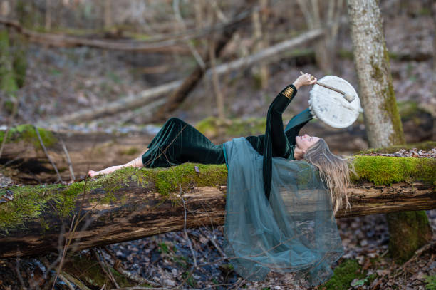 istock Woman playing a drum in a forest. Shallow depth of feld 2184417874