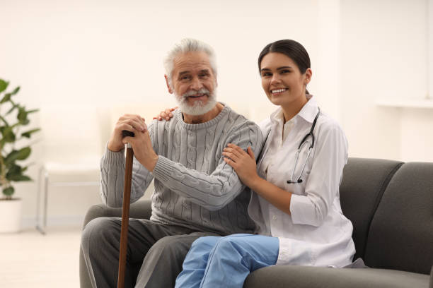istock Smiling nurse supporting elderly patient in hospital 2184421318