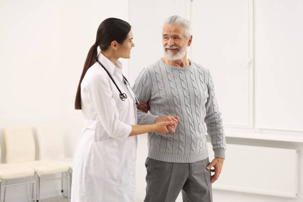 istock Smiling nurse supporting elderly patient in hospital 2184422056