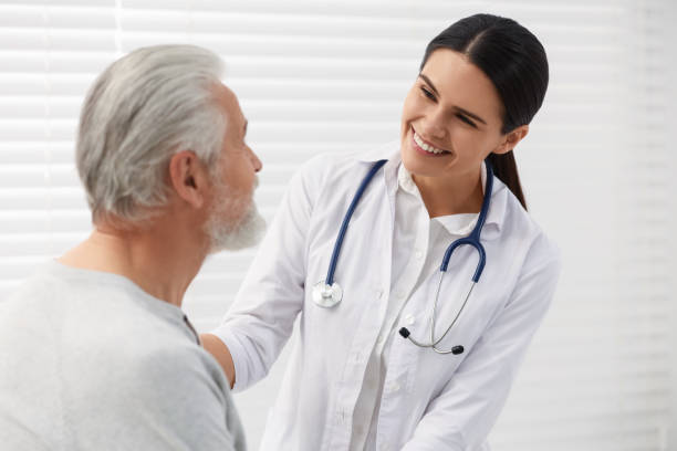 istock Smiling nurse supporting elderly patient in hospital 2184422086