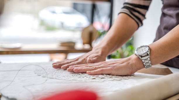 istock In an art studio with an environment adorned with artistic paintings in the background, a beautiful middle-aged woman artist is working on a lace pattern design on a clay plate at a table 2184422772